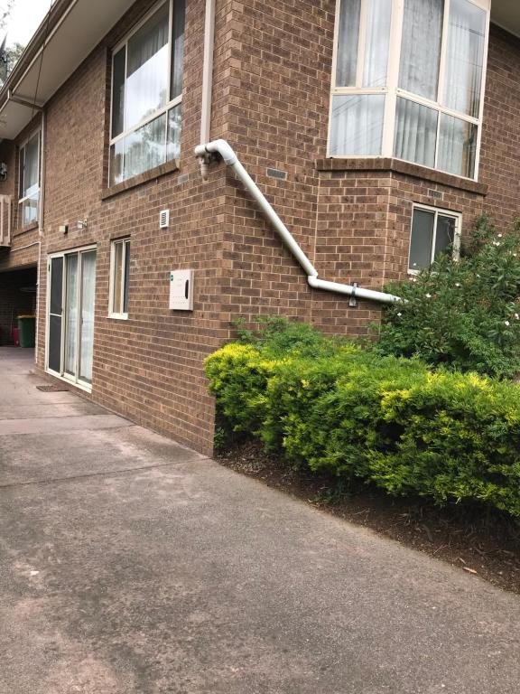 a brick building with a pipe on the side of it at Bethel Homestay in Watsonia North