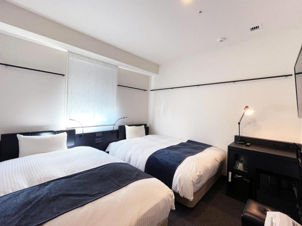 Postel nebo postele na pokoji v ubytování HOTEL SUI KANDA by ABEST