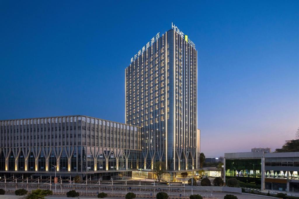 a tall building is lit up at night at Home2 Suites by Hilton Guiyang Airport in Guiyang