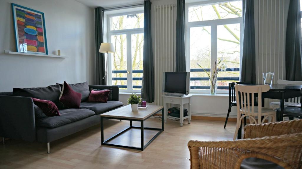 a living room with a couch and a table at Little Suite - Jean in Lille