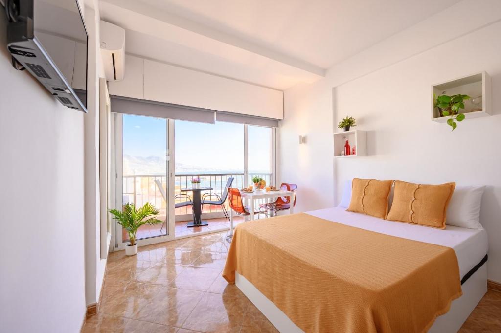 1 dormitorio con 1 cama y balcón en Sea & Mountain, front line, 1 min to beach by 10ToSea en Fuengirola