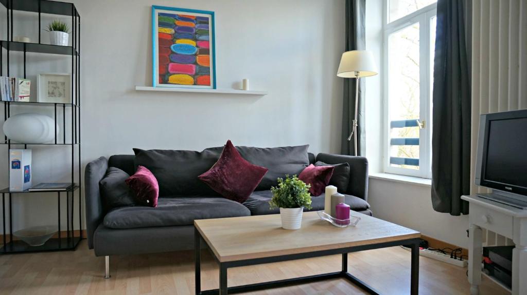 un salon avec un canapé et une table basse dans l'établissement Little Suite - Jean, à Lille