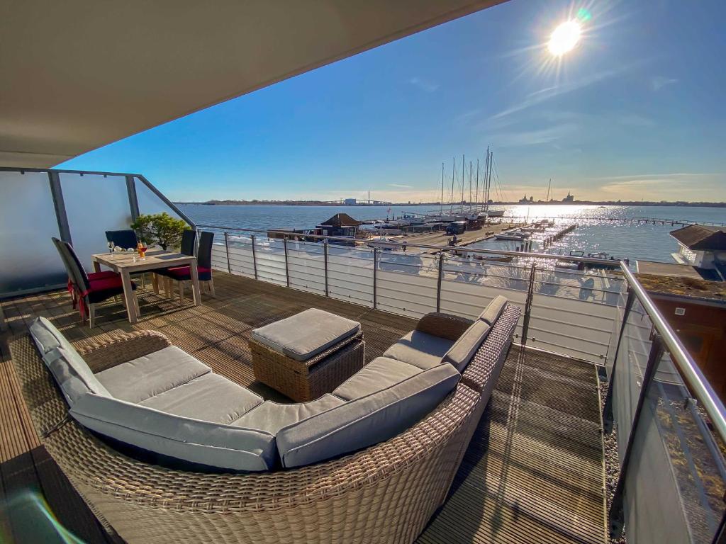 a balcony with wicker chairs and a table on a boat at Haus Putbus in Altefähr - WG 3 mit Panoramablick in Altefähr