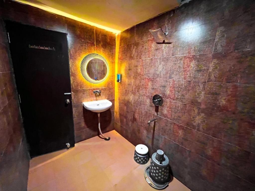 W łazience znajduje się umywalka i lustro. w obiekcie The कस्तूरी w mieście Maihar