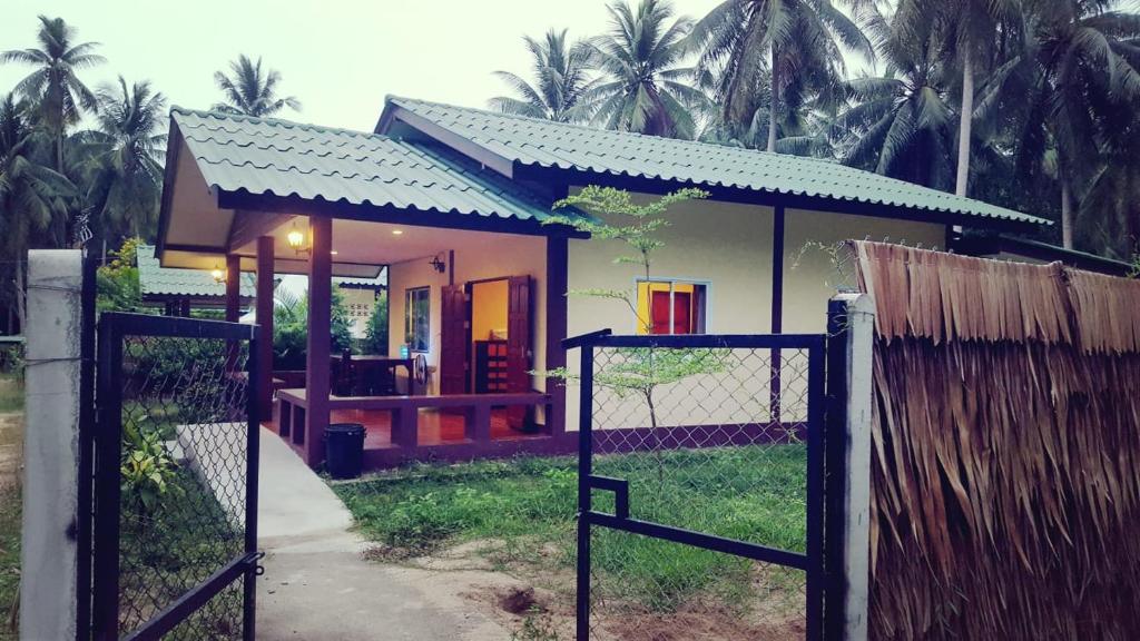 a small house with a gate in front of it at Ban Tai - Nice house in a quiet area 2 min from main road in Thong Sala