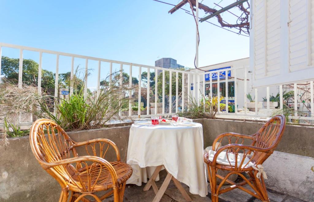 einen Tisch mit 2 Stühlen und eine weiße Tischdecke auf einer Terrasse in der Unterkunft Apartment Capitano Blue in Dubrovnik