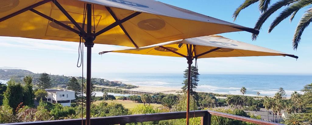 two yellow umbrellas on a balcony overlooking the ocean at The Tops in Wilderness