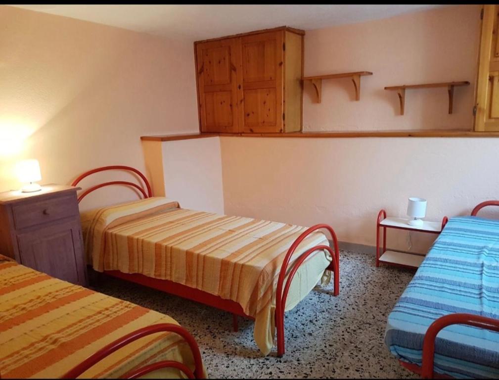 Habitación con 2 camas y armarios de madera. en Casa vacanze Nietta, en Cala Liberotto