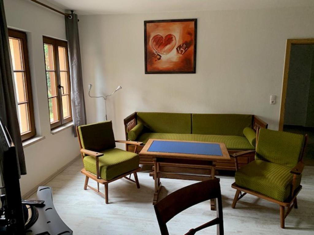 een woonkamer met een bank en een tafel en stoelen bij NEU! FeWo History Aschersleben in Aschersleben