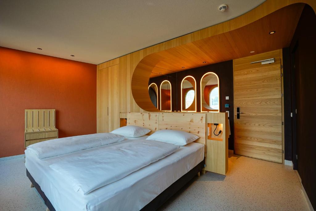 a bedroom with a large white bed with orange walls at La Briosa in Bolzano
