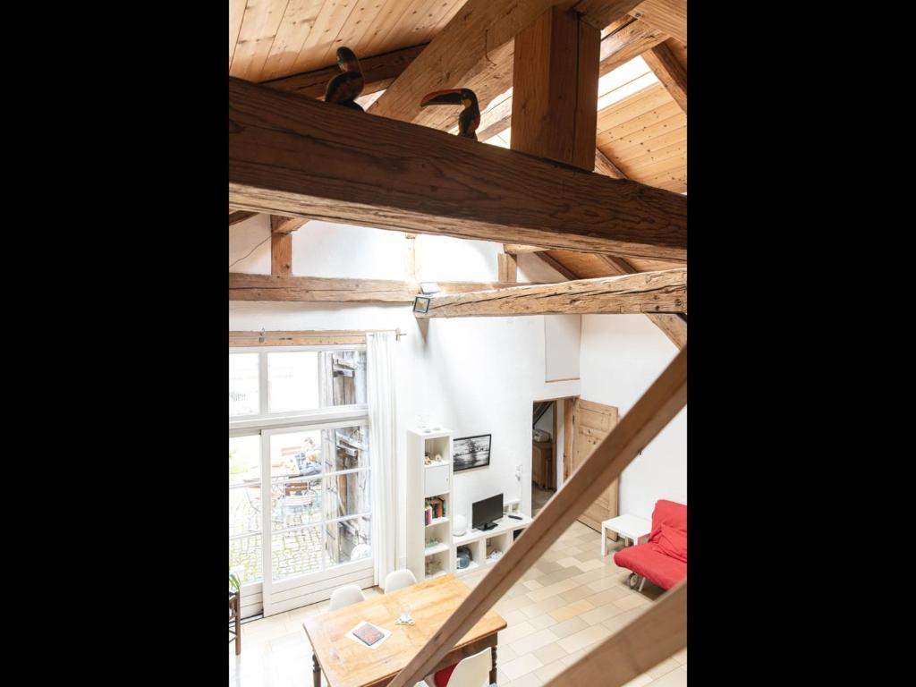 um quarto no sótão com vigas de madeira e uma mesa em NEU! Studio Beim Kirchschuster em Schernfeld