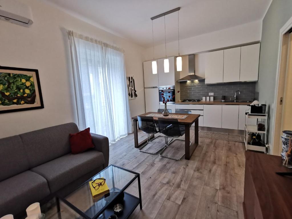 een woonkamer met een bank en een tafel en een keuken bij Dagnino House - Luxury apartment in the center of Palermo in Palermo