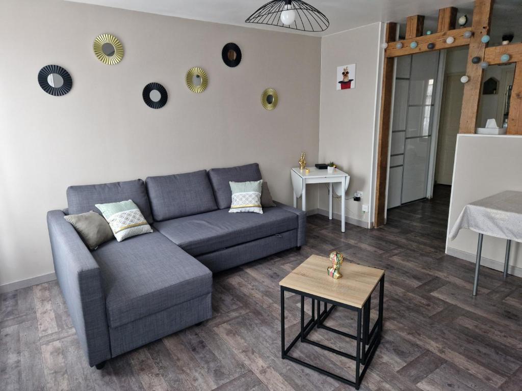 een woonkamer met een blauwe bank en een tafel bij Joli appartement T2 Agglo Troyes in Sainte-Savine