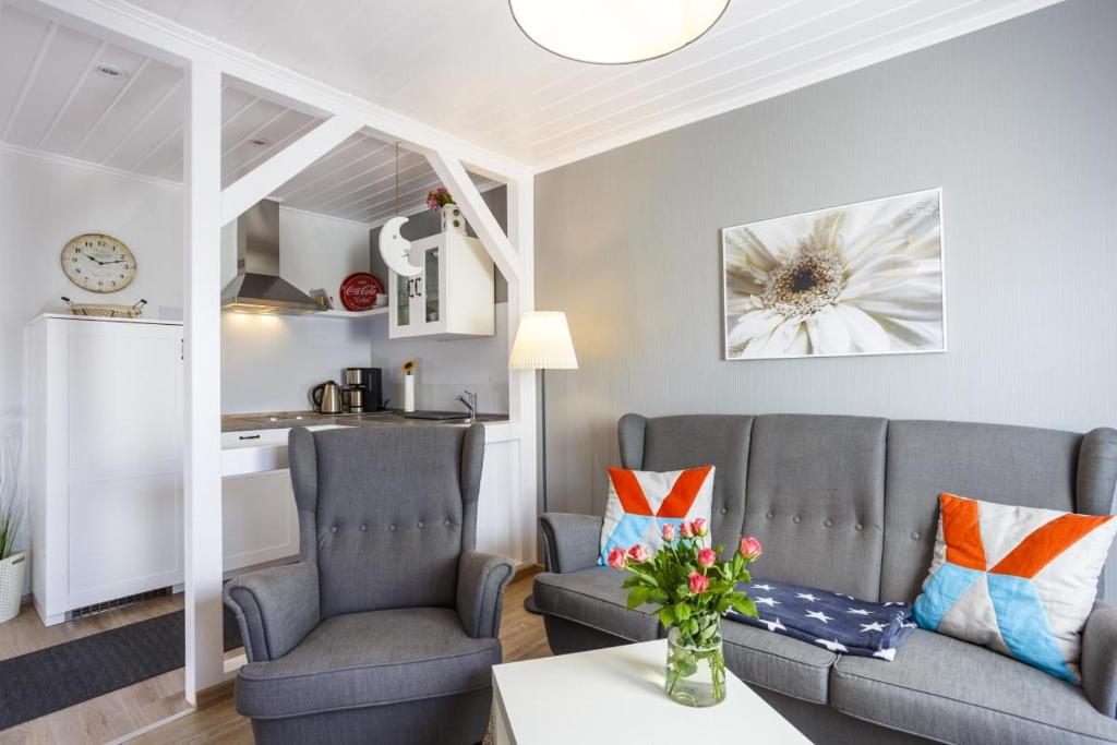 ein Wohnzimmer mit 2 Sofas und einer Küche in der Unterkunft Ostseeliebe, gemütliche und moderne Ferienwohnung für 2 Personen in Zingst in Zingst