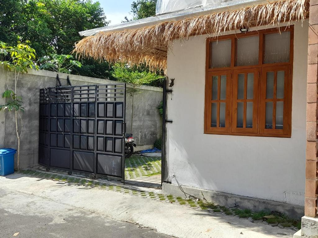 a house with a door and a window and a fence at Bring In House Yogyakarta in Yogyakarta