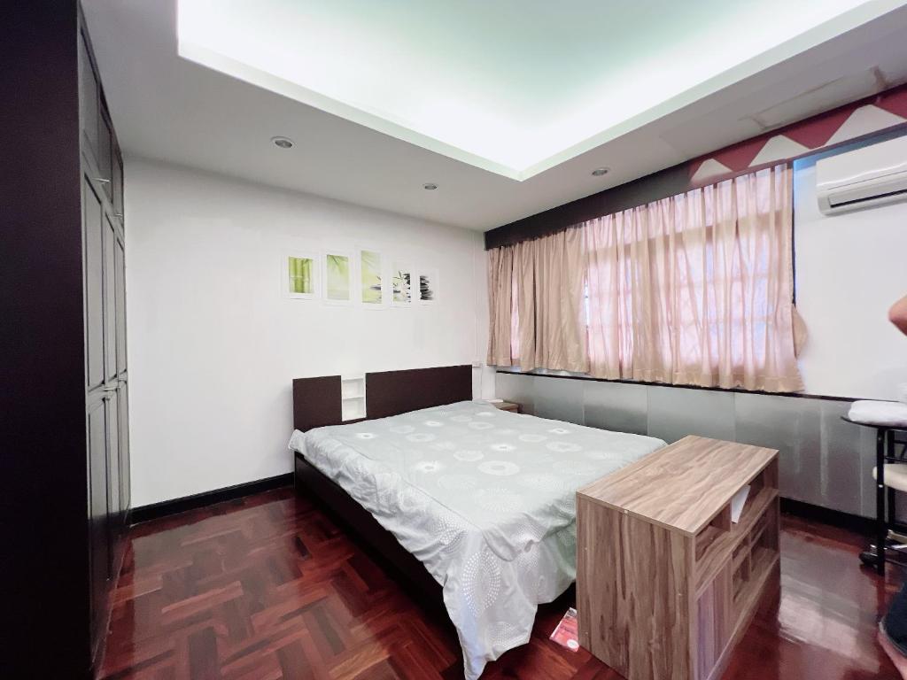 a bedroom with a bed and a table in it at Flourish Apartments Sukhumvit 39 in Bangkok