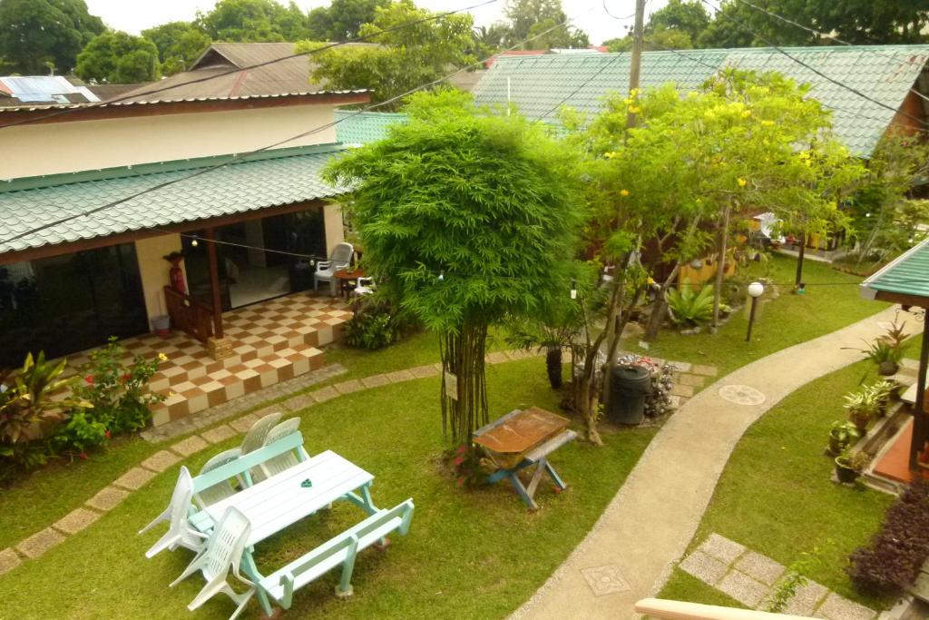 una vista sul parco con panchina e alberi di Cheers Garden Chalet a Kampung Tekek