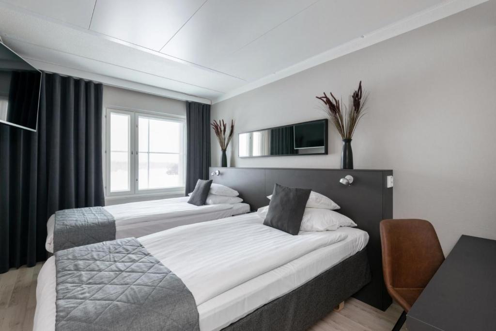 ハメーンリンナにあるオリジナル ソコス ホテル ヴァークナ ハメーンリンナのベッド2台とデスクが備わるホテルルームです。