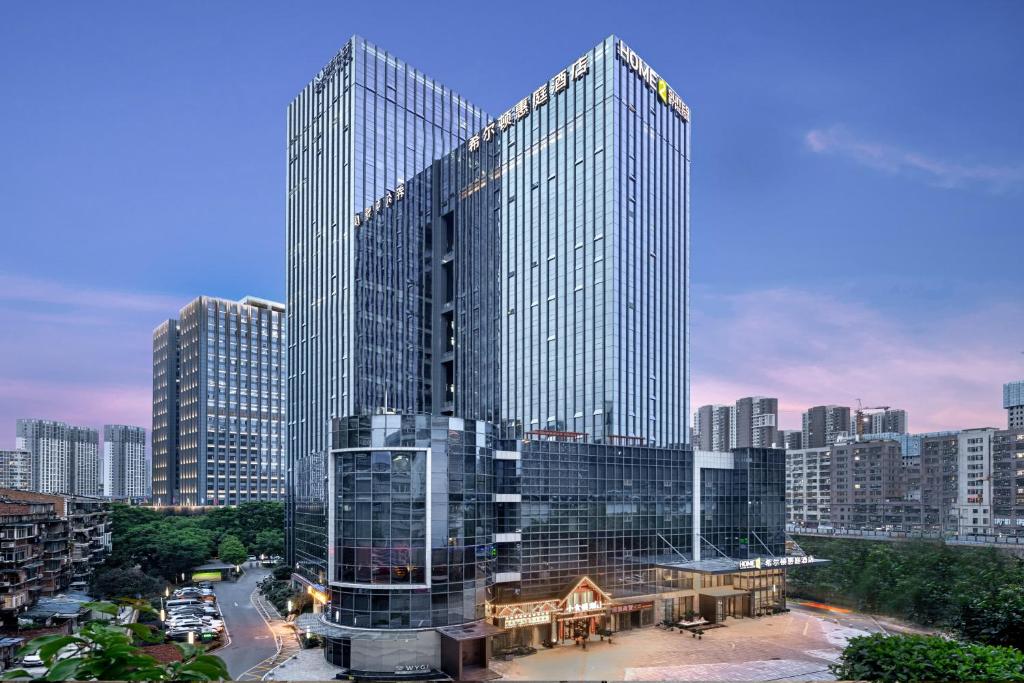 ein hohes Glasgebäude in einer Stadt in der Unterkunft Home2 Suites By Hilton Wuhan Xudong in Wuhan