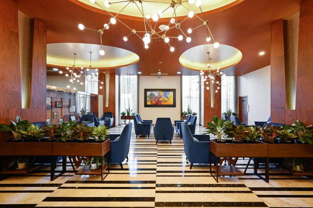 ホーチミン・シティにあるMuong Thanh Grand Saigon Centre Hotelの建物内の椅子とテーブルのあるロビー