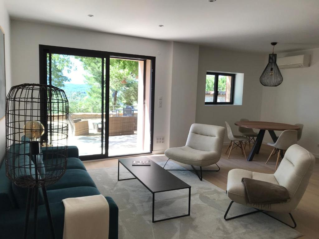 un salon avec un canapé, des chaises et une table dans l'établissement La Bastide - Le Grenache - Le Syrah au Domaine Chateau Henri Bonnaud, au Tholonet