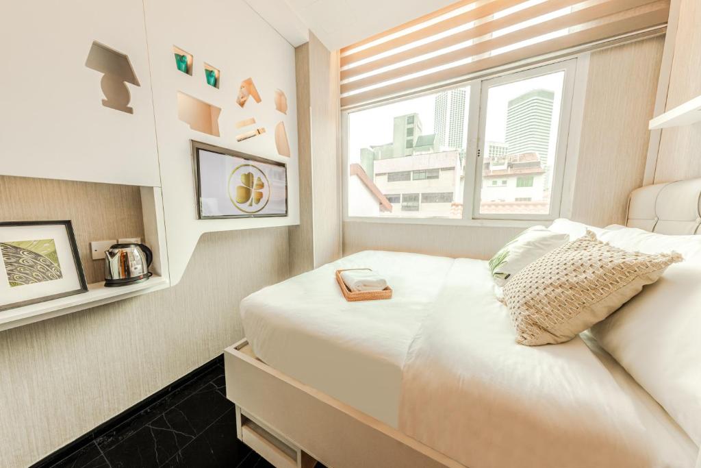 a small room with two beds and a window at D'Nova Hotel Bugis in Singapore