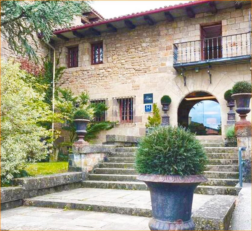 a stone building with stairs and a vase with a plant at Hotel Luze El Toro in Berrioplano