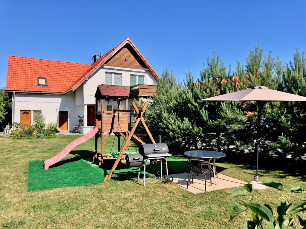 a playground with a slide and a table and an umbrella at Apartamenty Sun & Snow Villa Sportowa in Mysłakowice