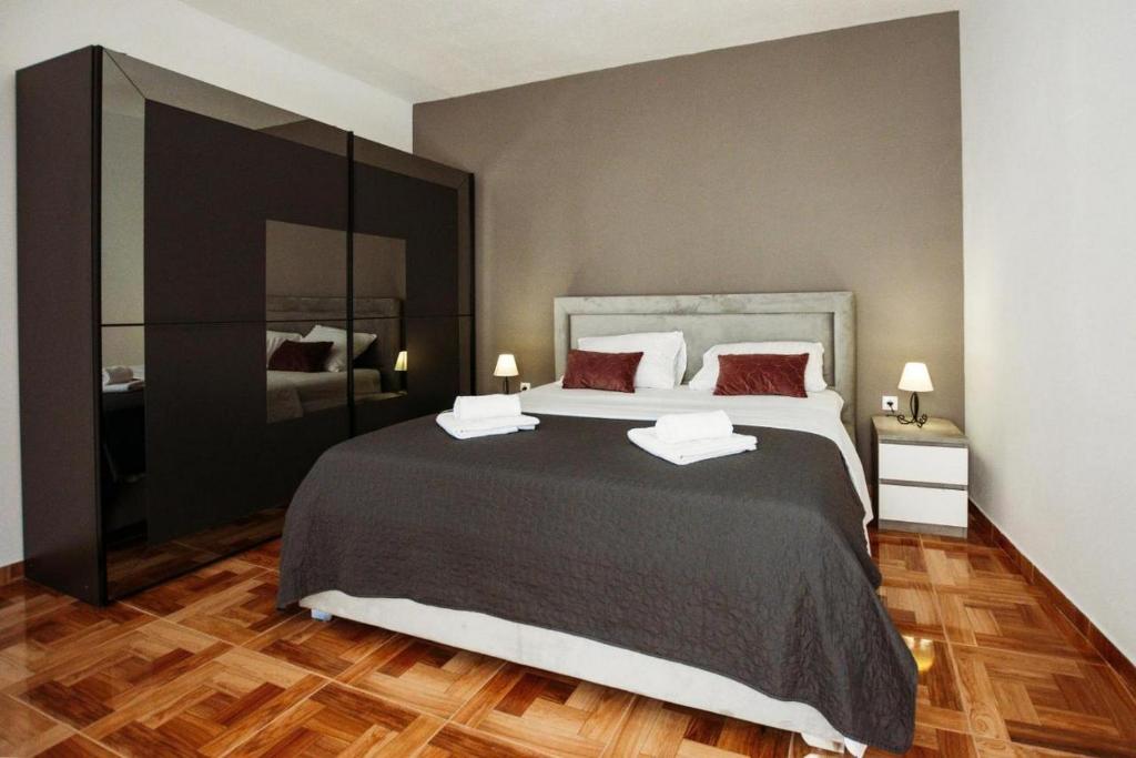 Un dormitorio con una cama grande con dos almohadas rojas. en Apartment Essenza, en Zadar