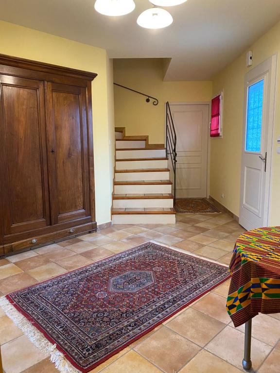 a living room with stairs and a rug on the floor at La Peyreyre in Jaujac