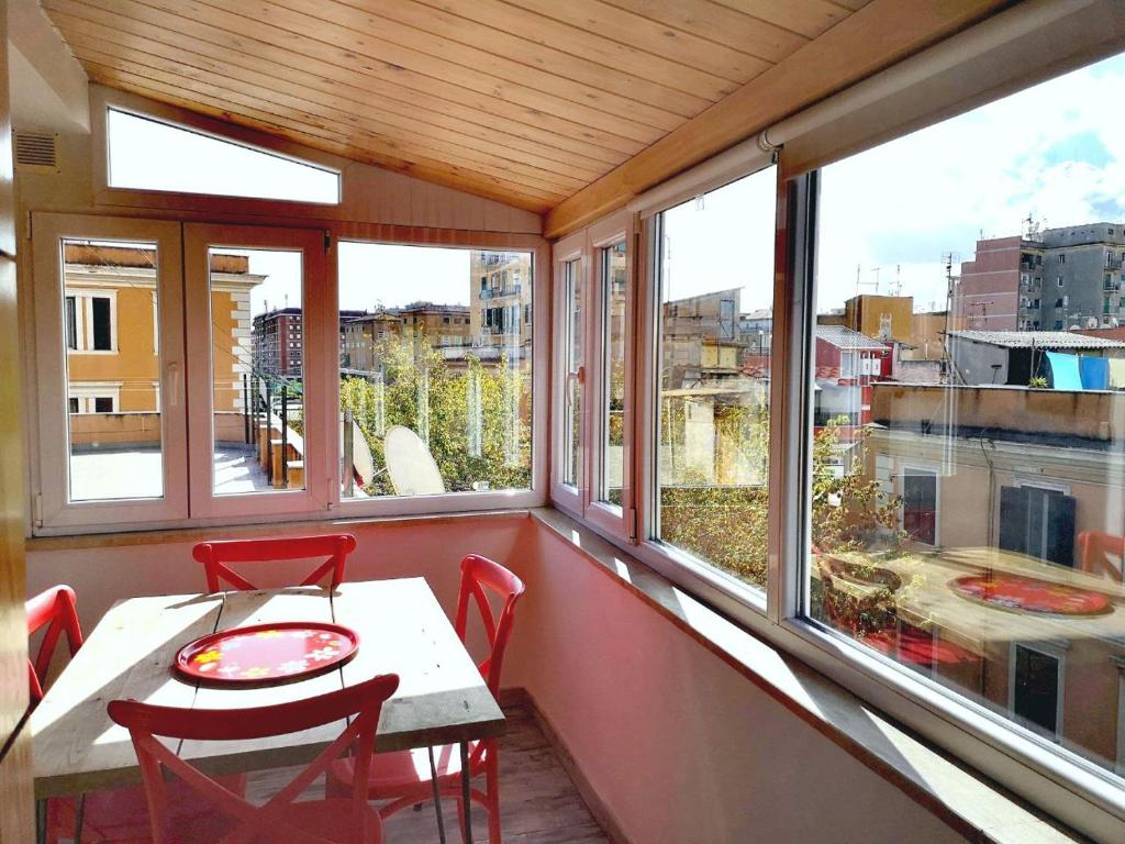 a balcony with a table and chairs and windows at Soulmate Rooftop Apartment in Rome