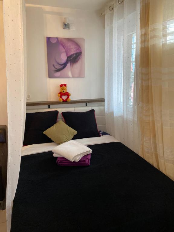 um quarto com uma cama com um cobertor preto em Résidence Zola em Villeurbanne