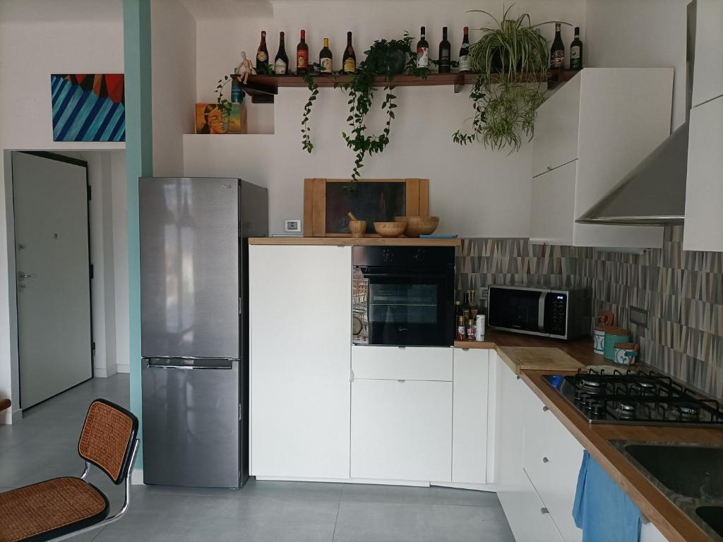 una cucina con armadi bianchi e frigorifero in acciaio inossidabile di City View! Panoramic Apartment overlooking La Spezia a La Spezia