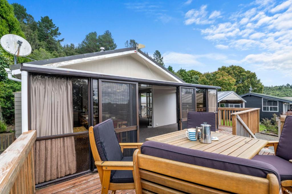 a deck with a table and chairs on a house at Point Retreat - Lake Rotoiti Holiday Home in Rotoiti
