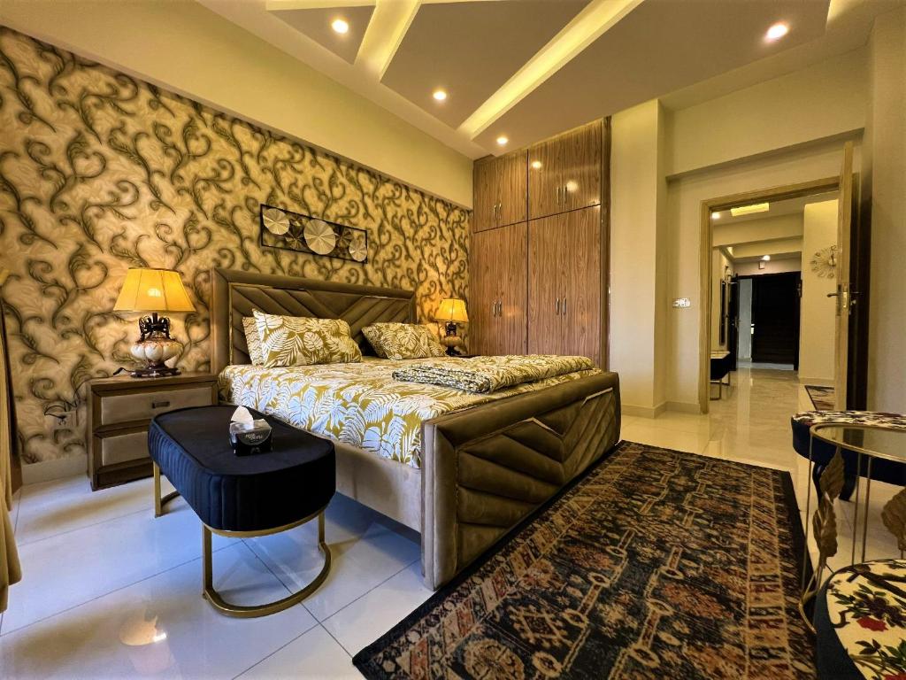 1 dormitorio con 1 cama grande y 1 mesa en The Realtors Inn 1 BDR Apartment DHA 2 en Islamabad