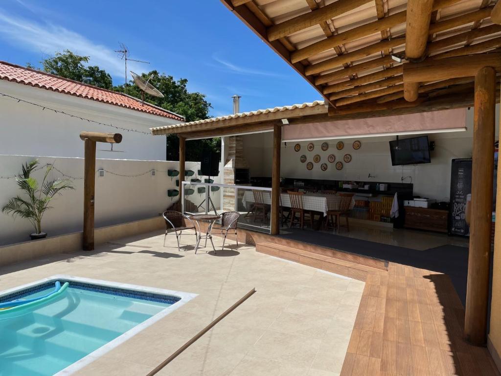 une terrasse avec une piscine et une maison dans l'établissement Casa Top Vilas, à Lauro de Freitas