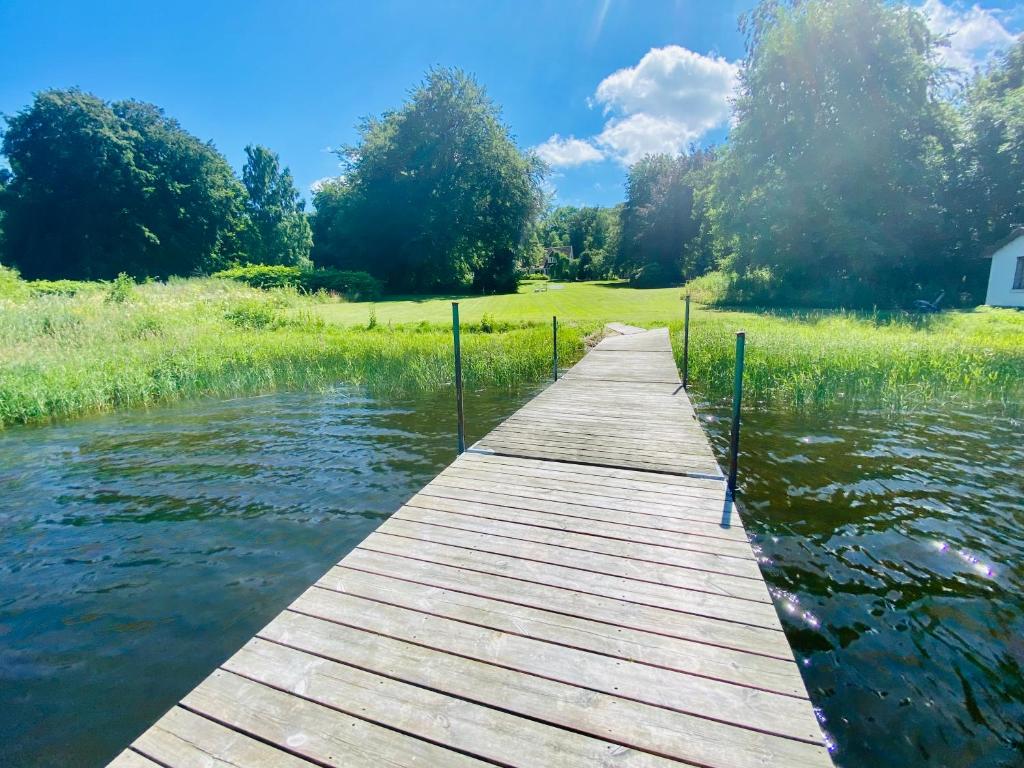 a wooden bridge over a body of water at Ringsjö Wärdshus Stugor in Höör