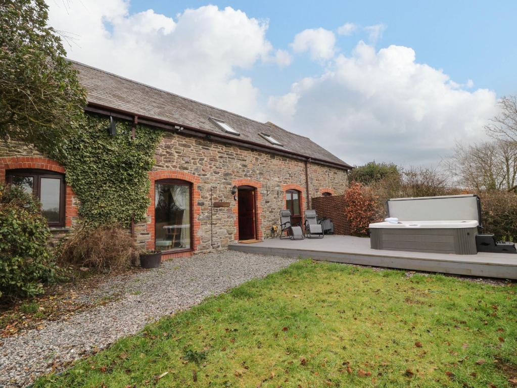 une maison en briques avec un barbecue à l'extérieur dans l'établissement The Hawthorns, à South Molton