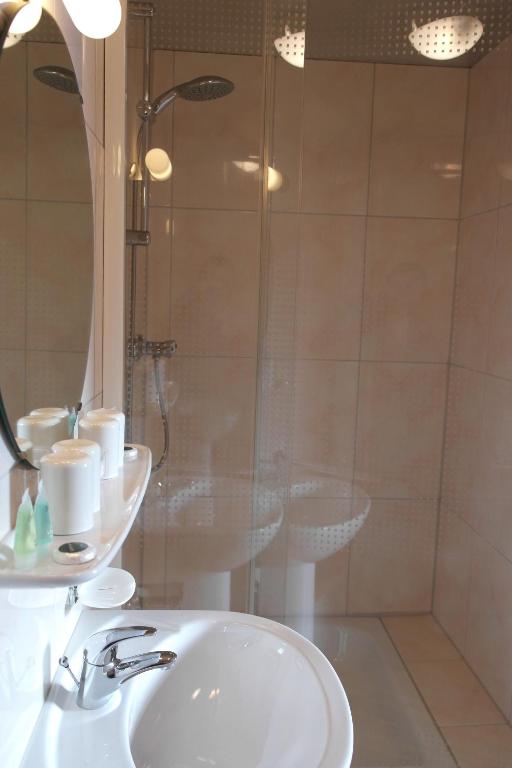 a bathroom with a white sink and a shower at Zum Goldhahn in Amblève