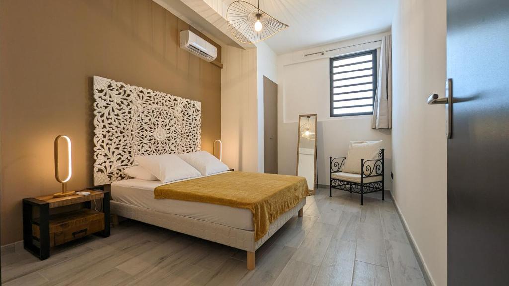 1 dormitorio con cama y ventana en Villa des 3 sables, CAPUCIN en Étang-Salé les Bains