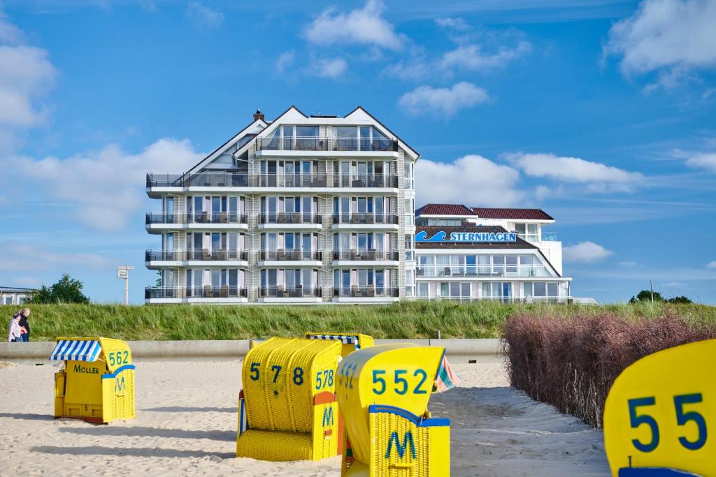 ein Hotel am Strand mit gelben Liegestühlen in der Unterkunft Badhotel Sternhagen in Cuxhaven