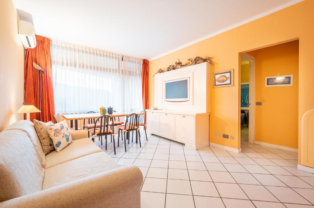 a living room with a couch and a tv at 100 metri dal mare in Lido di Camaiore