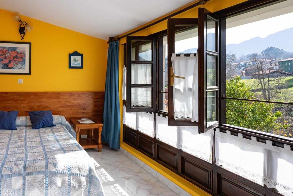 a bedroom with a bed and windows with a view at Casa rural El Cotero Lines in Porrúa