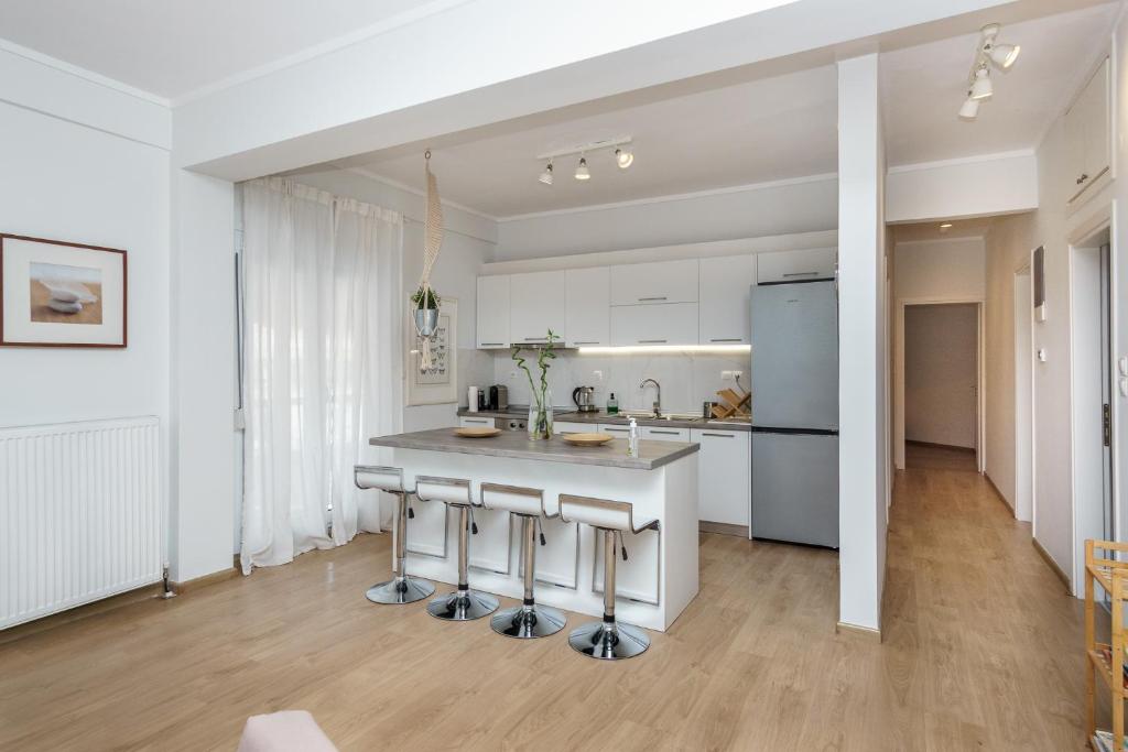 a kitchen with white cabinets and a counter top at Cataleya #colony city center in Thessaloniki