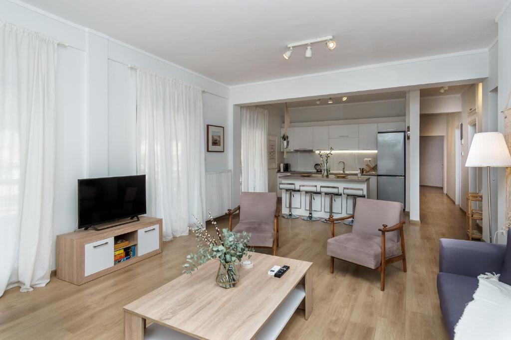 a living room with a couch and a tv and a table at Cataleya Thessaloniki - Urban Stay in Thessaloniki