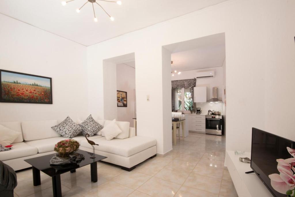 a living room with a white couch and a table at Gogo's Cosy Beach House in Rethymno