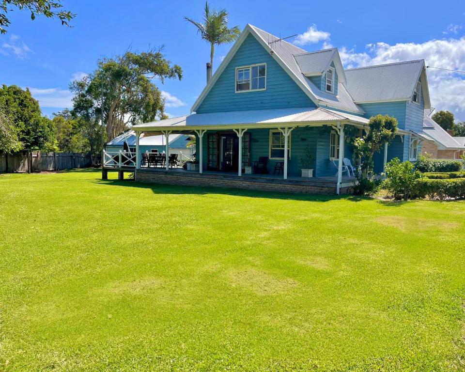 een blauw huis met een grote tuin bij Blue Pearl - Old Bar Holiday Rentals in Old Bar