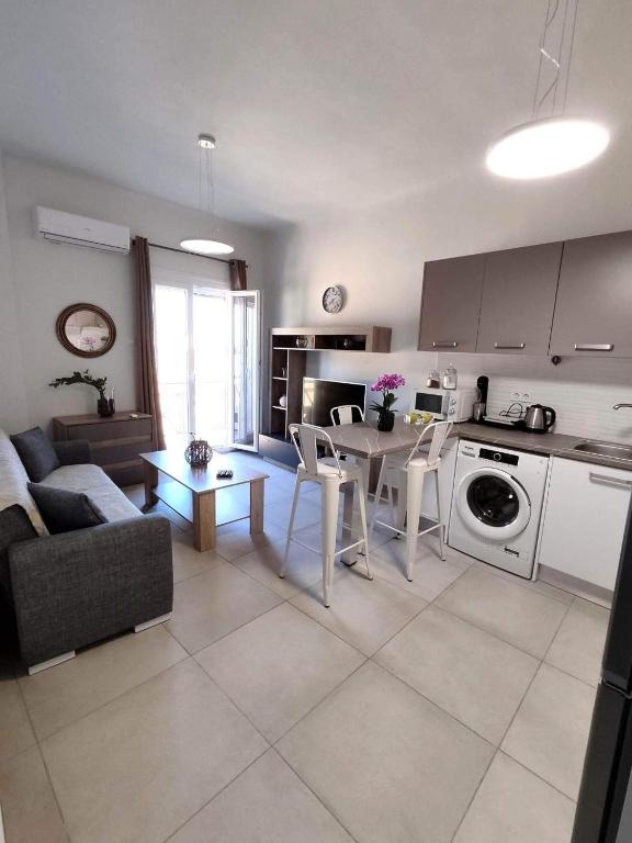a kitchen and living room with a couch and a table at Athanasia's Place in Ermoupoli