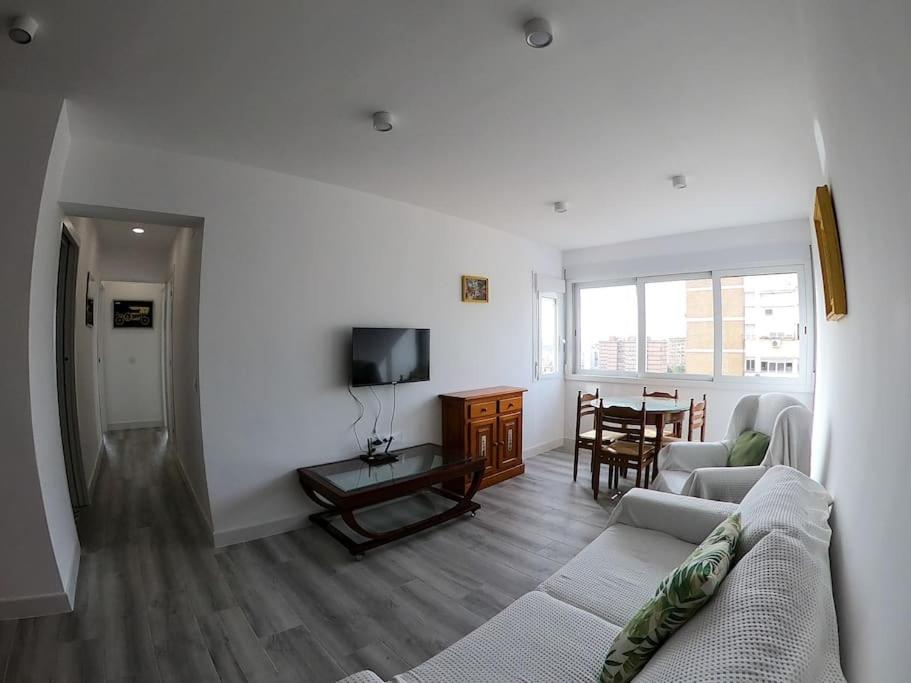 uma sala de estar com um sofá, uma televisão e uma mesa em ROCH - Stylish Apartment near Metro em Sevilha