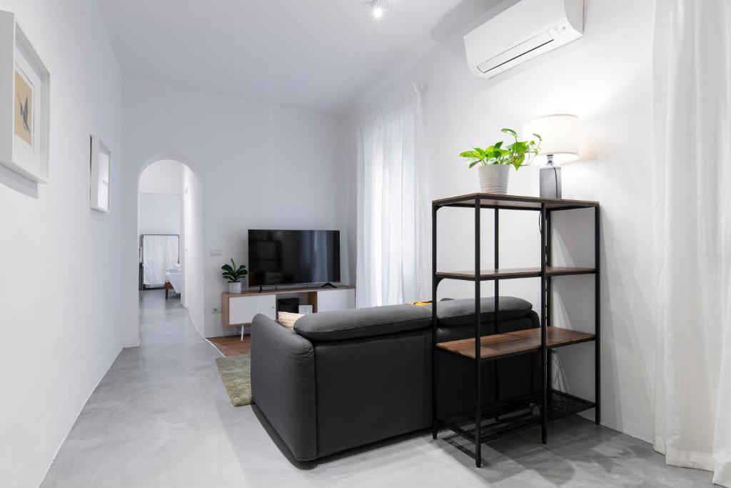 Una sala de estar con un sofá negro y un televisor. en San Frediano Elegant, en Florencia